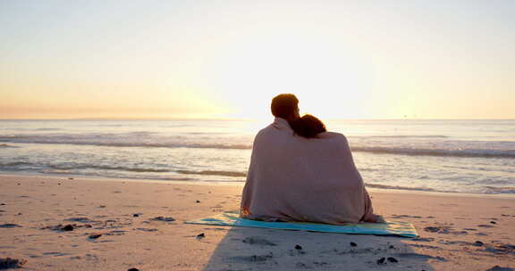 双生子裹在毯子里，看着海滩日落和复印空间