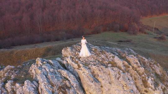 新娘穿着婚纱站在悬崖上