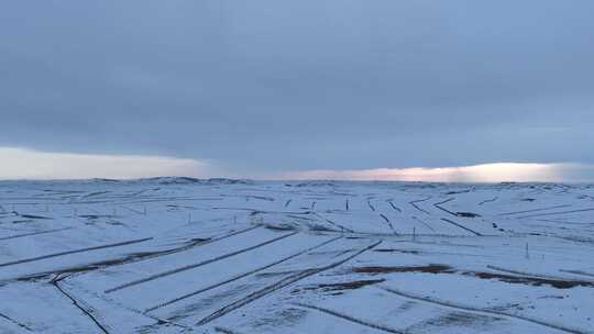 航拍浓郁夕阳下的垦区雪原