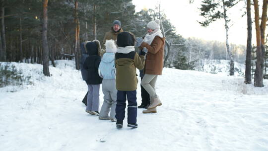 一家人在白雪皑皑的森林里玩耍