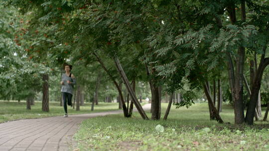 女士在公园道路上跑步视频素材模板下载
