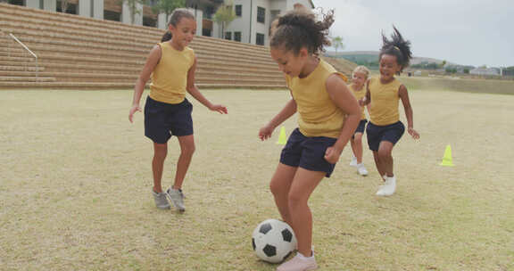 快乐的多样化女孩在学校前踢足球的视频