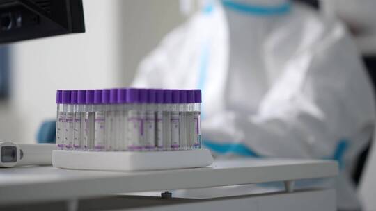 实验室防护服护目镜科研人员比对着试管工作