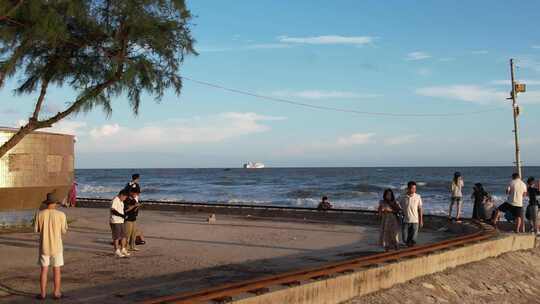 人们在海边沙滩上游玩的欢乐场景