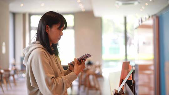 年轻女子在咖啡店使用智能手机通讯