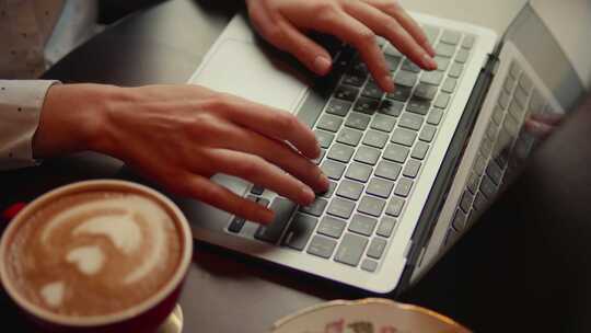 咖啡馆里在笔记本电脑上打字的女人
