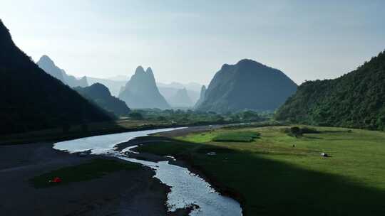 阳光下桂林山谷中的河流草地和露营基地