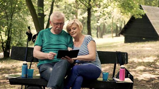 夫妇在森林里看电子书