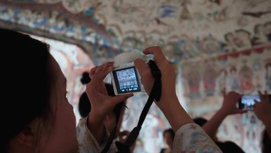 游客用手机在敦煌莫高窟洞窟内拍摄