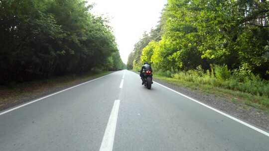 摩托车手在伍德兰乡村公路上骑摩托车比赛，