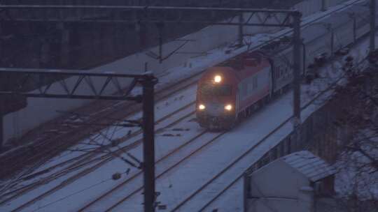 傍晚下雪一列火车飞驰通过下满雪的铁路