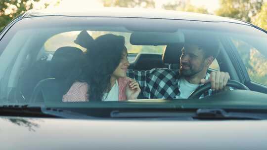 快乐的男人坐在车里拥抱他的女朋友慢动作