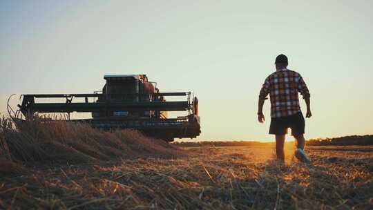 一个农民在夕阳下走在麦田里