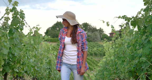 美丽微笑的女孩（女人）农民戴着草帽，穿着