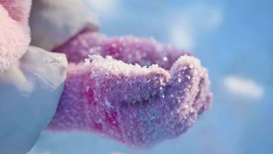 冬季阳光下儿童手捧雪花特写