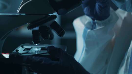 4K-穿防护服看显微镜的科学家视频素材模板下载