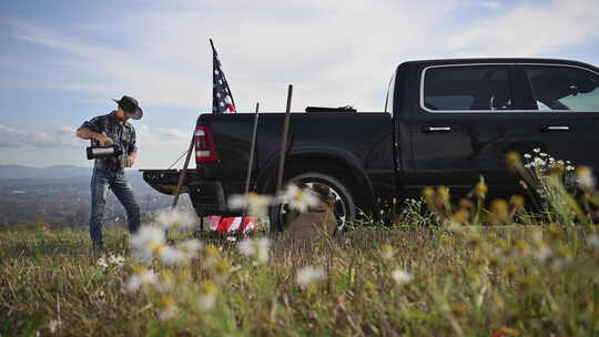 美国牛仔在卡车旁喝咖啡