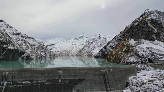 令人惊叹的无人机镜头在阿尔卑斯湖、水坝和被崎岖的穆包围的巨大阿尔卑斯水库上空