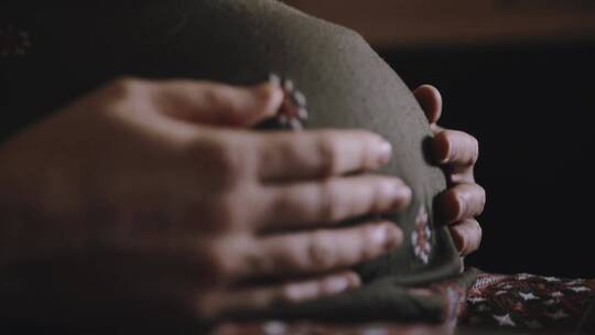 孕妇抚摸孕肚的特写镜头视频素材模板下载