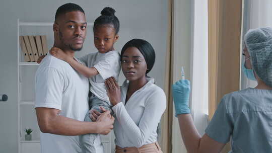 严重的非裔美国家庭黑人父母抱着非洲女孩女儿站在医院