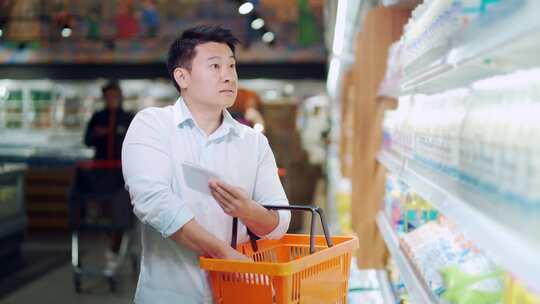 每天在超市杂货店购物的亚洲男子使用清单提视频素材模板下载