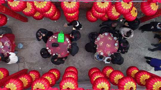 红灯笼下人群围桌聚餐场景