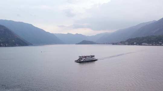 风景如画的科莫湖上的客轮，背景是意大利阿尔卑斯山，空中有