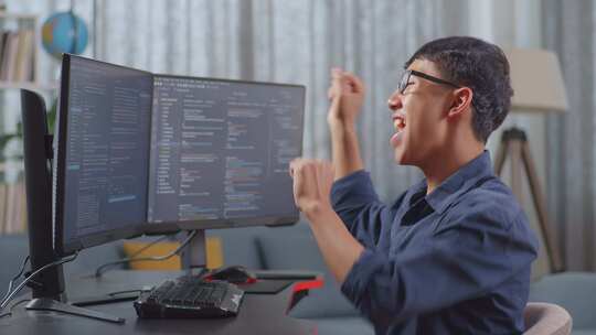 亚洲少年男孩程序员庆祝成功创建软件工程师开发应用程序