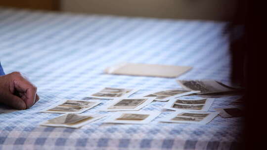 手触摸放置在桌布上的老照片