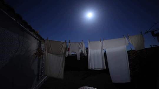 月夜下晾晒衣物的场景