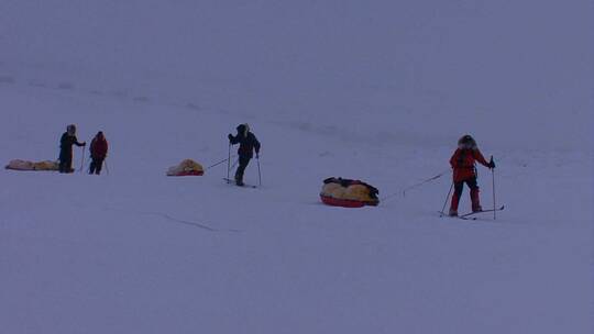 北极探险队用越野滑雪板拖拽物资