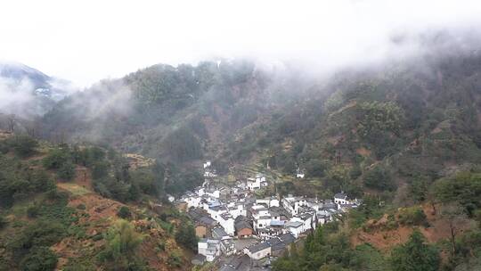 皖南冬天晨雾中的乡村和雪山