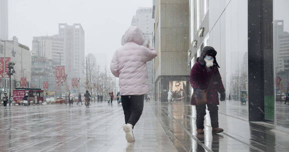 疫情冬日下雪的成都街头行人带口罩防疫