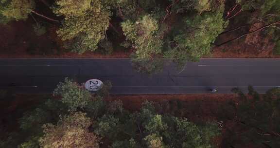 无人机在森林道路上起飞，自行车道限速为20公里。白色货车