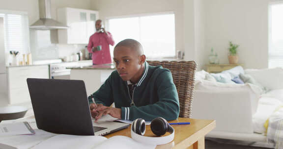 专注的非裔美国男孩带着笔记本电脑在家上在线课程的视频