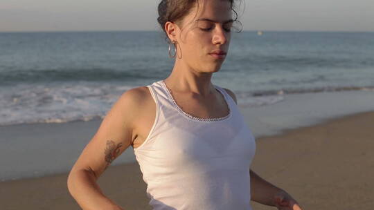 年轻的女人在海边做瑜伽视频素材模板下载