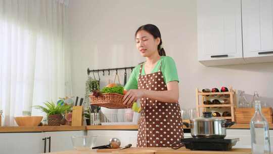 亚洲年轻女子早上在家厨房烹饪健康食品。