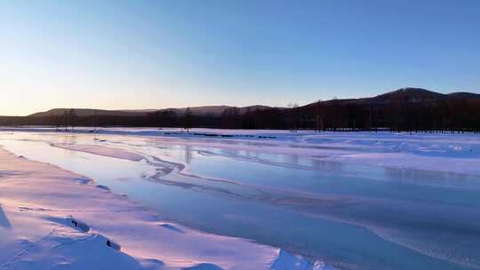 夕阳下内蒙古北方不冻河平静水面雪雾袅袅