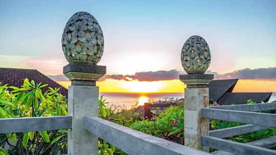 巴厘岛阿梅德海滩日出与海面背景下的灯笼花卉图案雕塑沙石