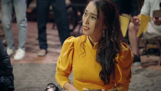 身着黄色传统服装的迷人越南女子在会安街玩