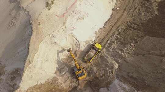 挖掘机将沙子装入自卸卡车