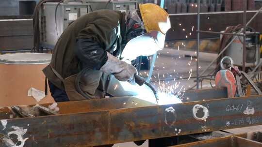 工厂的电焊工焊接钢材升格