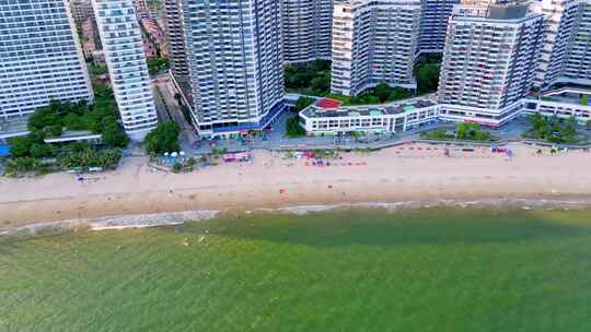 海滨城市高楼边的沙滩和海水景象