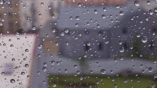 雨滴滴落在窗户上特写