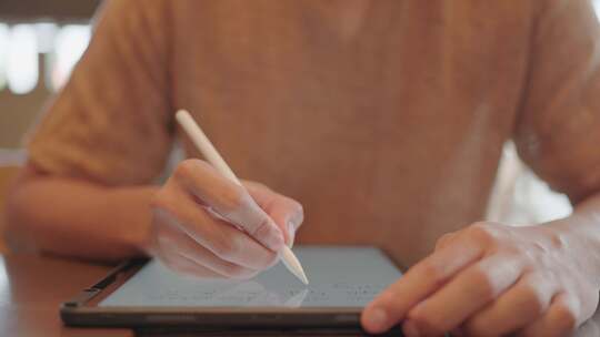 男人用ApplePencil电容笔在平板电脑上写字