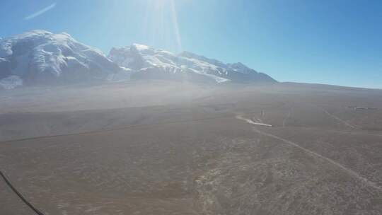 新疆正午雪山脚下飞驰过的汽车航拍视频素材模板下载