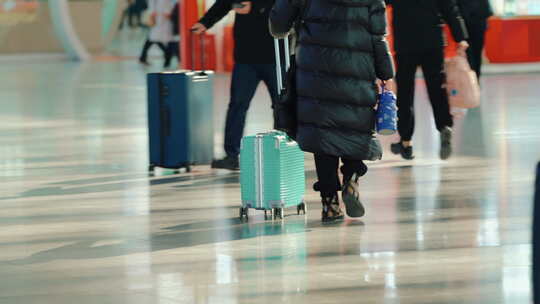 南京火车站里匆匆忙忙拿着行李走过的乘客