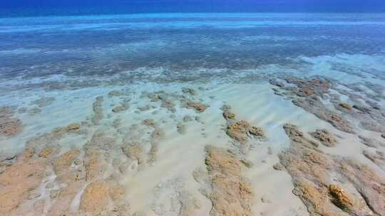 浅蓝色海洋中的白沙珊瑚礁