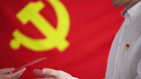 在红色党旗前新党员接过中国共产党章程