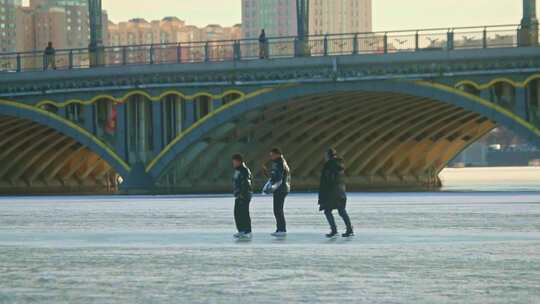 结冰湖面青年人游玩 冰面滑行 壮观大桥唯美